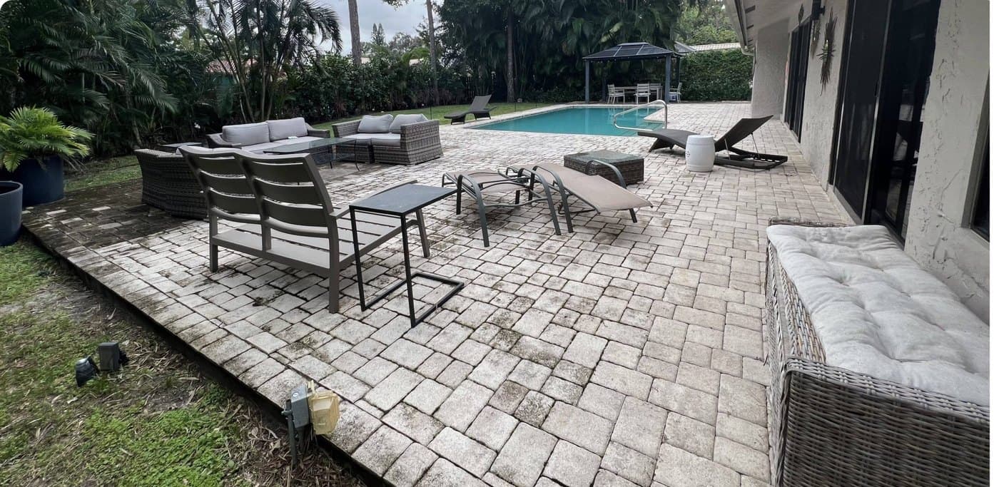 Pool-deck pavers before — stained gray with algae and grime